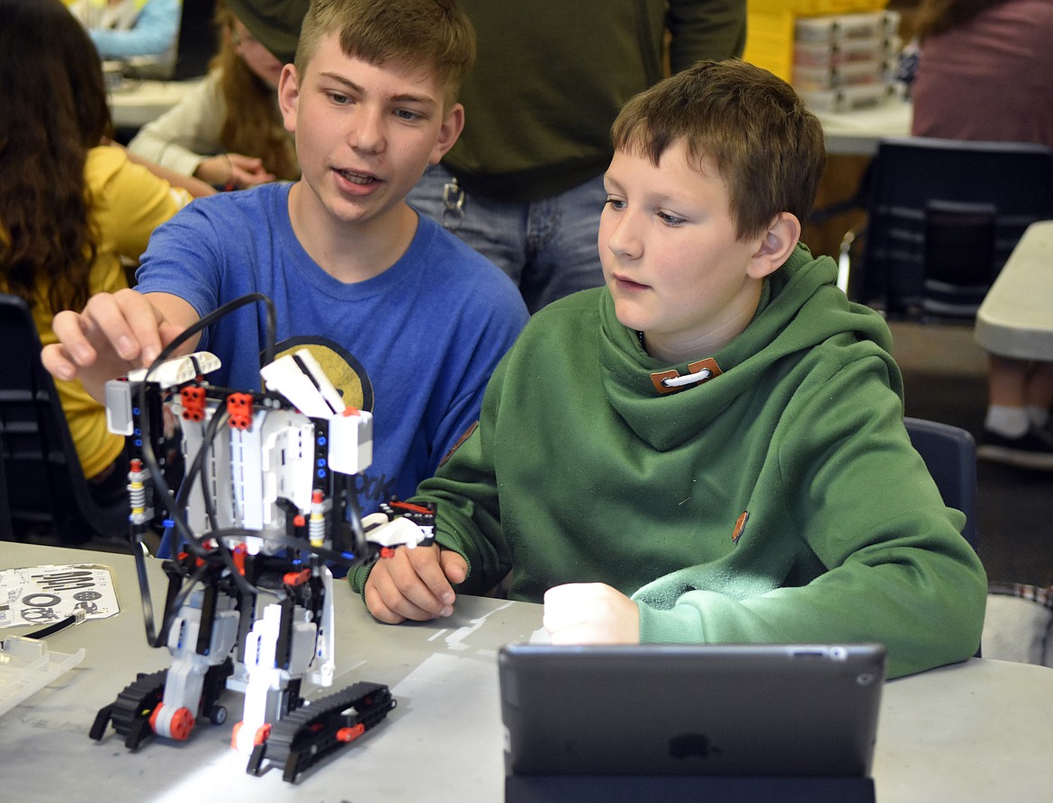 Jace Fanning and Jeremy Scott discuss how to construct their robot at Olney-Bissell School during a recent camp. Students got the chance to construct robots using LEGO MINDSTORMS kits and then program them to complete different actions. (Heidi Desch/Whitefish Pilot)