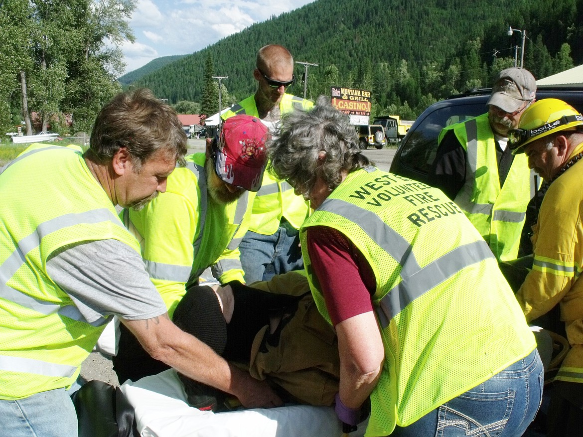 From left, Frank Magee, Dick Hughes, Russell McKague, Donna Richter, Mike Richter, and Keith Woody load a practice dummy on a gurney during a recent training exercise. (Courtesy photo)