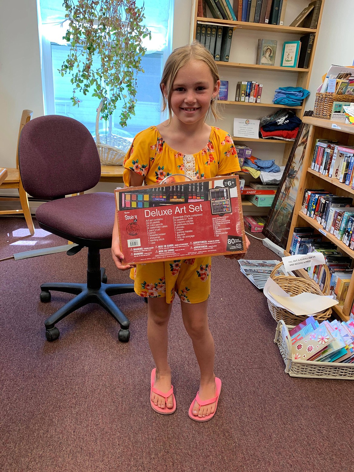 The Mineral County Library held the finale of their summer reading program Sunday, July 14. Leyna Vigue stands with her prize after she won the poster decorating contest for the third- and fourth-grade category. See more photos on Page A8. (Photo courtesy of Florence Evans)