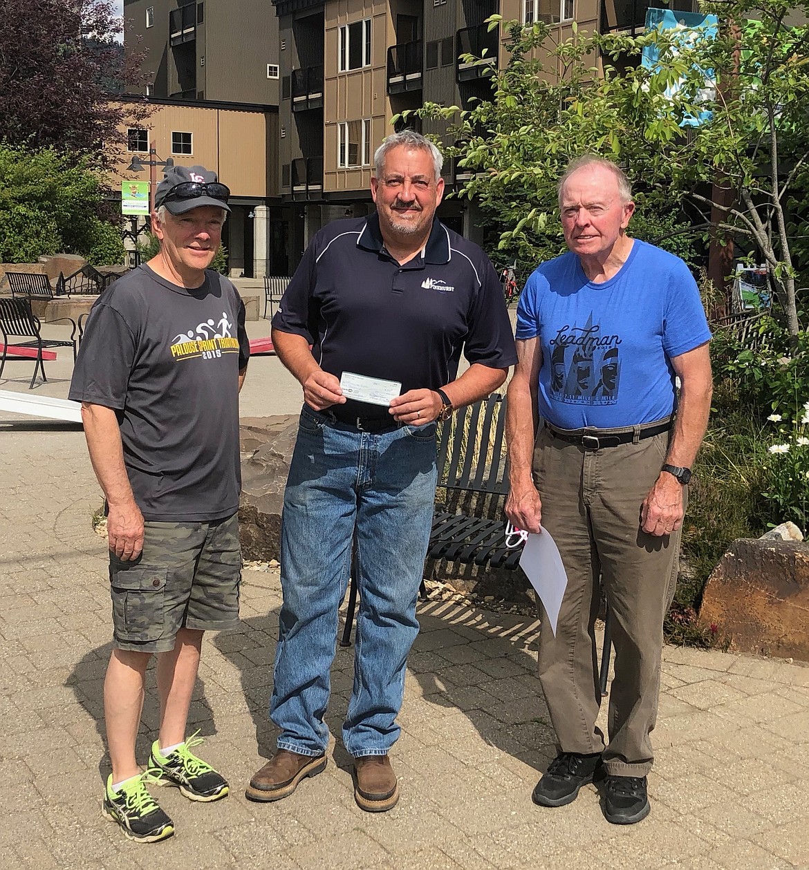 Sid Armstrong and Larry Currie present Pinehurst Elementary School principal Mike Groves with a check.