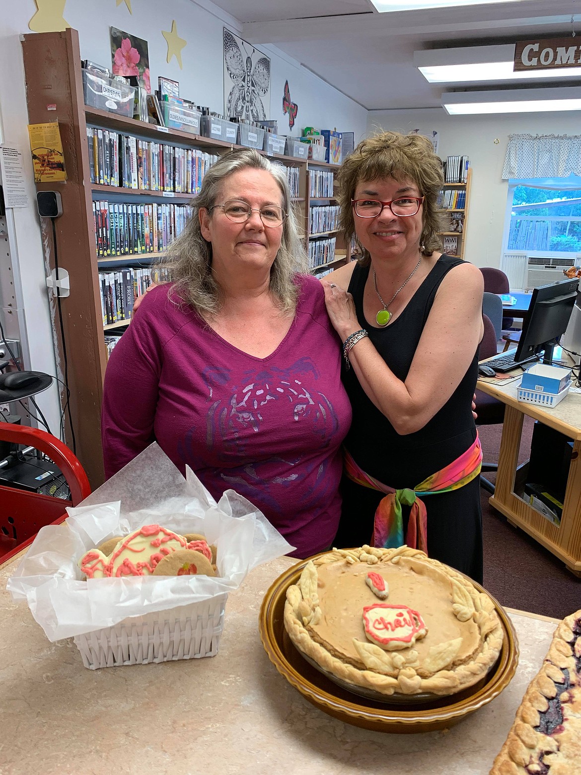 Debbie Kelsey and Leslie Budwitz pose with a cheesecake at the Summer Reading Program Finale. (Photo courtesy of Florence Evans)