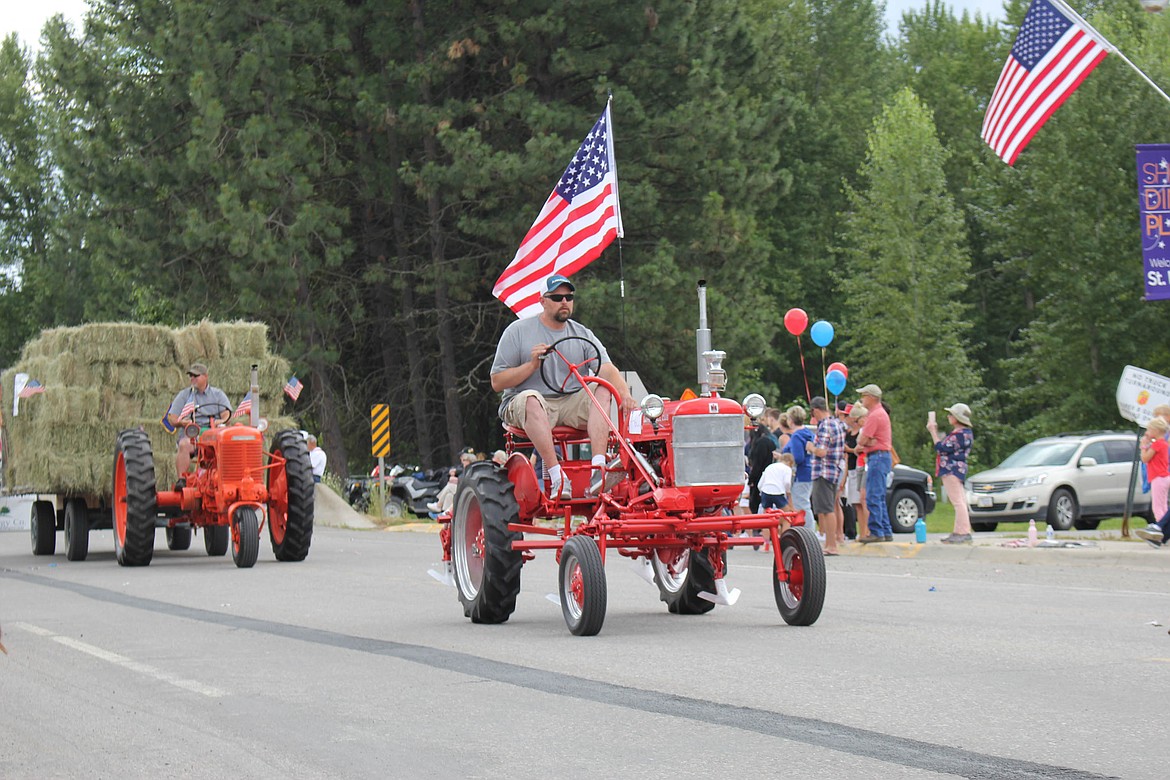 Tractors drive down Old U.S. Highway 10 during the St. Regis Fourth of July parade. (Maggie Dresser/Mineral Independent)