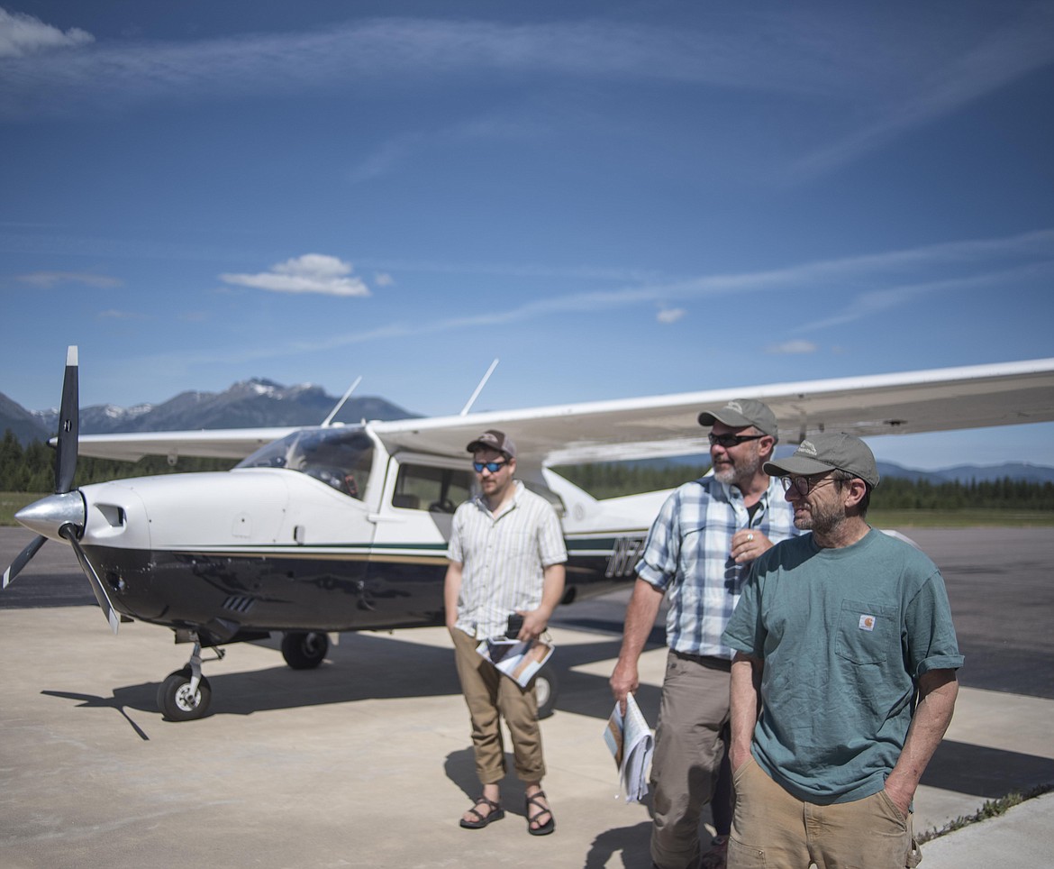 Rick Bass talks with other conservationists after flying between the Yaak and Cabinet Mountain areas, showing where the Pacific Northwest trail change would be, June 10 at the Libby Airport. (Luke Hollister/The Western News)