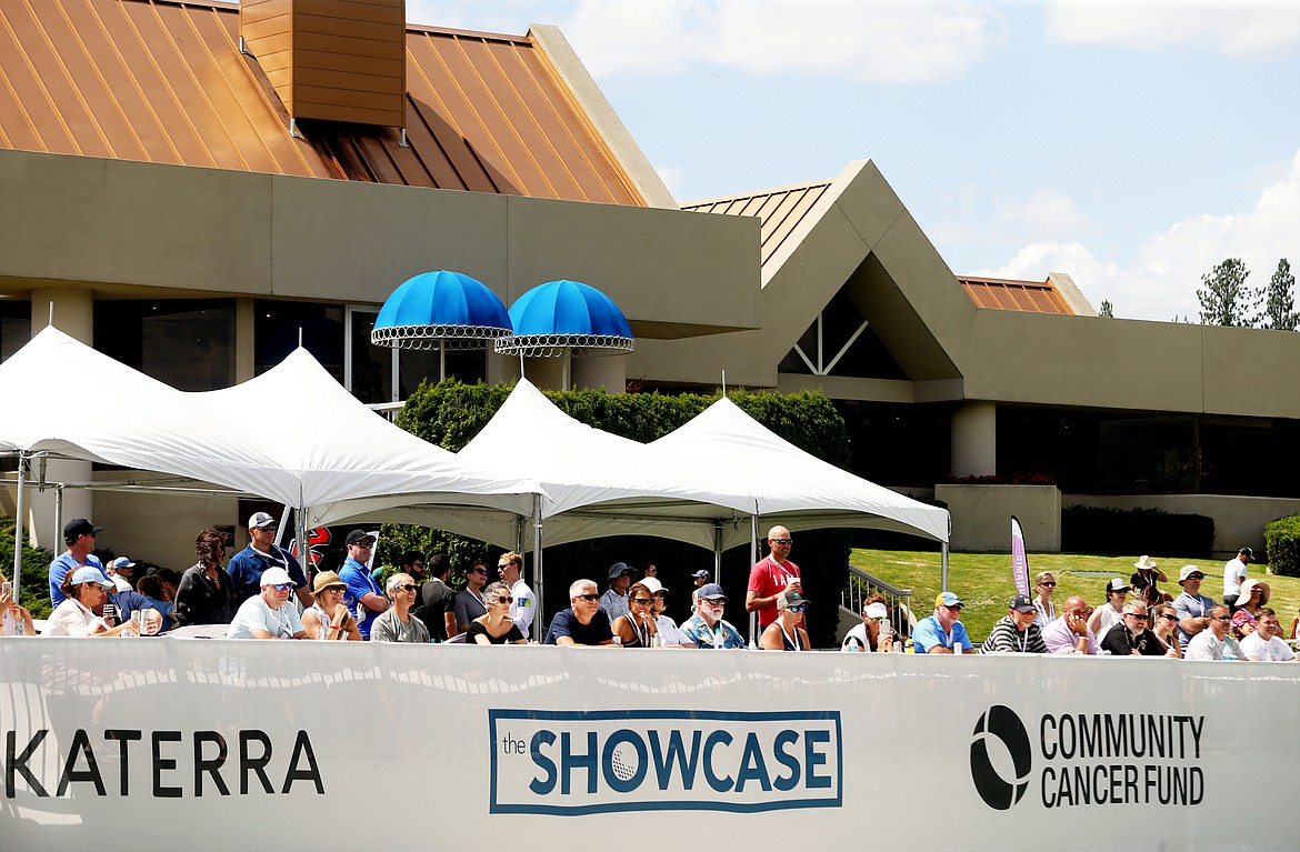 Fans in the VIP deck watch former professional baseball, hockey and basketball celebrities finish the 18th hole during the Showcase celebrity golf exhibition on Saturday at The Coeur d'Alene Resort Golf Course. (LOREN BENOIT/Press)