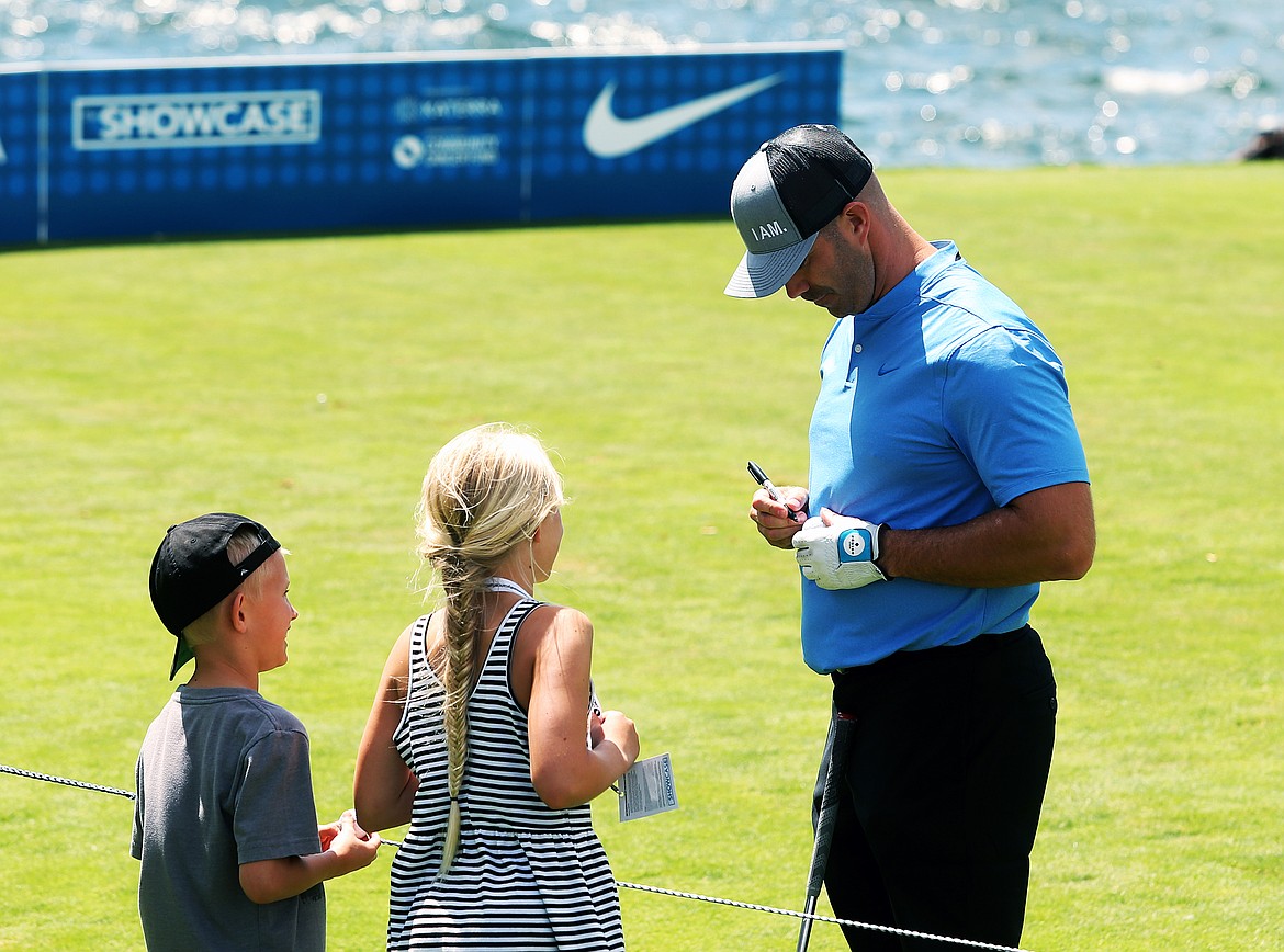 Former professional hockey player Barret Jackman signs two golf balls for two young fans at Saturday&#146;s Showcase.