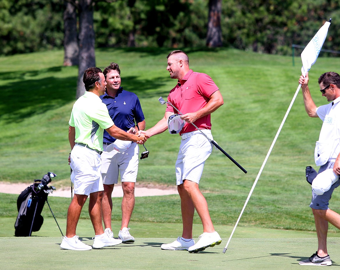 Former Spokane Chief Ray Whitney, left, and former NHL player Brenden Morrow, in blue, congratulate Mark Mulder on his Showcase win Saturday at The Coeur d&#146;Alene Resort Golf Course.