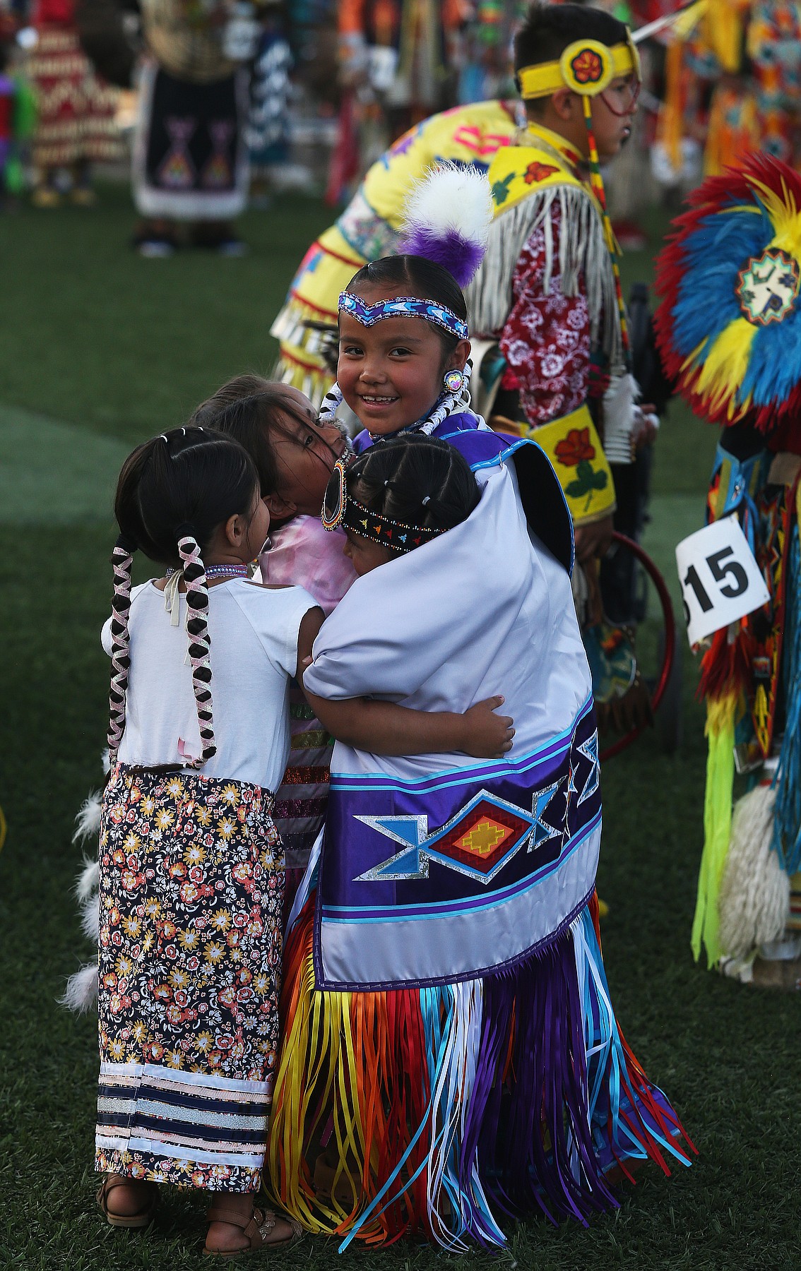 Akemi Michael-Mustache, 7, of the Coeur d&#146;Alene Tribe, hugs her cousins during Friday night&#146;s Julyamsh Grand Entry at the Kootenai County Fairgrounds. (LOREN BENOIT/Press)