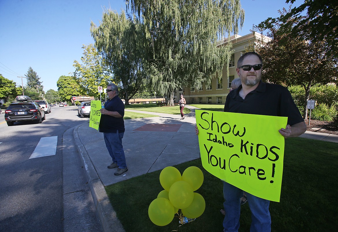 LOREN BENOIT/Press
Jeff Short, left, and Dennis Skellenger hold signs as cars pass by the Kootenai County Courthouse on Thursday. The trial of a Rathdrum 20-year-old accused of paying minors for sex has been postponed until October.