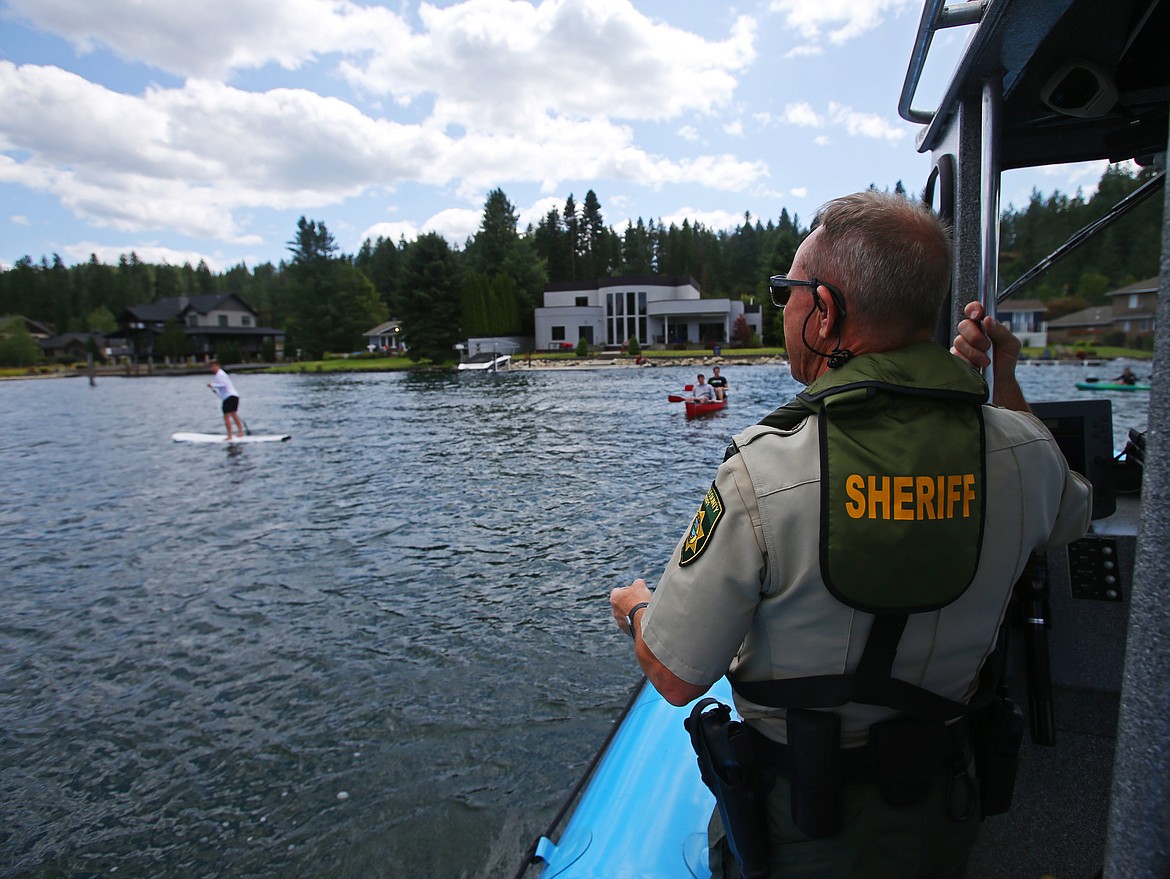 Kootenai County Sheriff Deputy Gerald Wallace reminds floaters to wear life vests while out on the Spokane River on Wednesday. (LOREN BENOIT/Press)