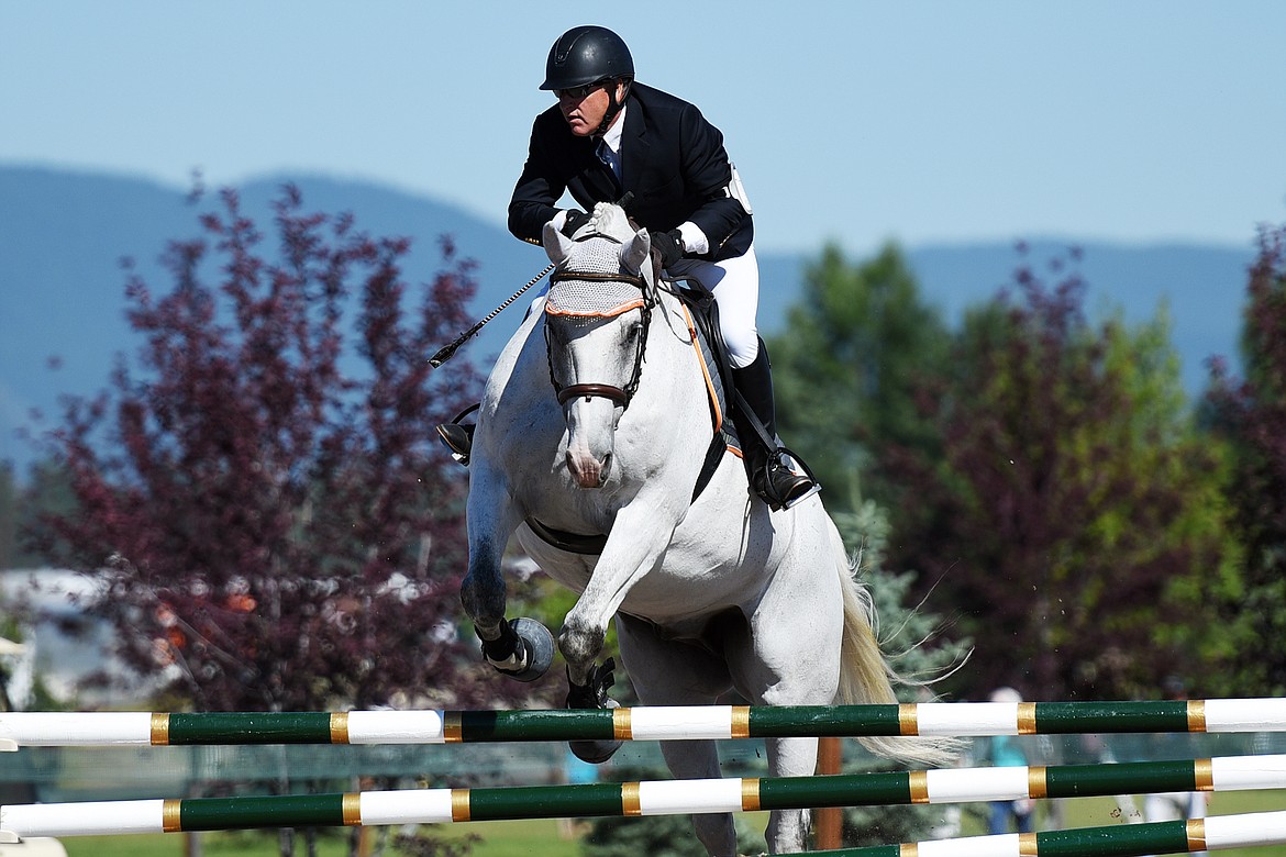 Derek Jackson rides Cosmic over a jump in the Senior Open Novice B show jumping division during The Event at Rebecca Farm on Friday. (Casey Kreider/Daily Inter Lake)