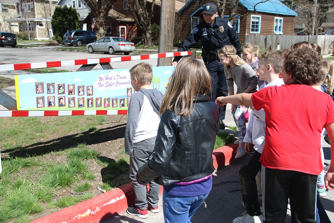 (Photo by MARY MALONE)
Washington Elementary third graders excitedly point out their photos on the new sign attached to the gate in front of the school. As second graders, the group took on a Design for Change project to make the intersection in front of their school a safer place. Several changes were subsequently made, including the addition of the gates.