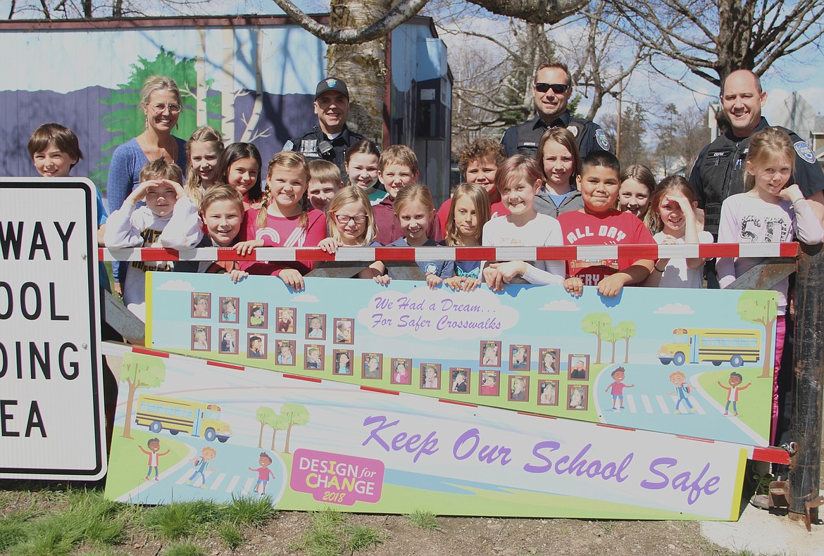 (Photo by MARY MALONE)
A group of Washington Elementary third graders show off the new signs they designed for the gates in front of the school. As second graders, the group took on a Design for Change project to make the intersection in front of their school a safer place. Several changes were subsequently made, including the addition of the gates.