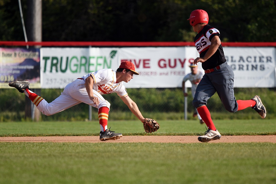 Kalispell Lakers AA third baseman Randy Stultz tries to reach a first-inning grounder against the Helena Senators AA at Griffin Field on Saturday.