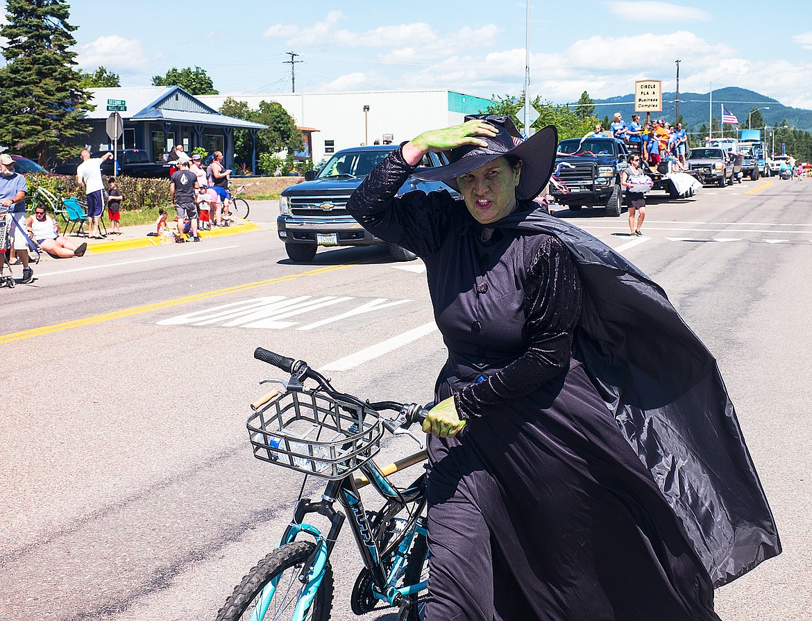 The Wicked Witch of the West holds her hat on.