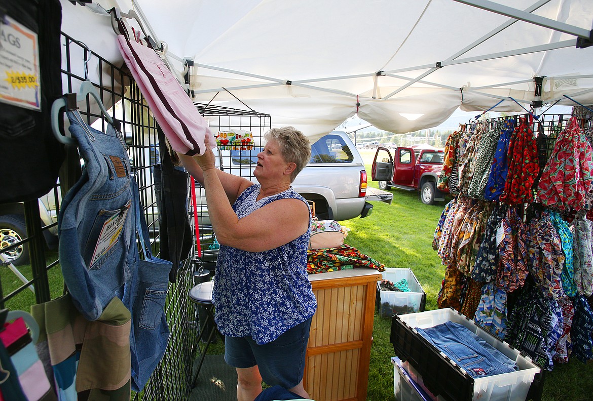 Rene Miller sets up her Ever Clever Connections booth Friday prior to Rathdrum Days this weekend. Rene sells a variety of bags like these recycled jean bags for $20. (LOREN BENOIT/Press)