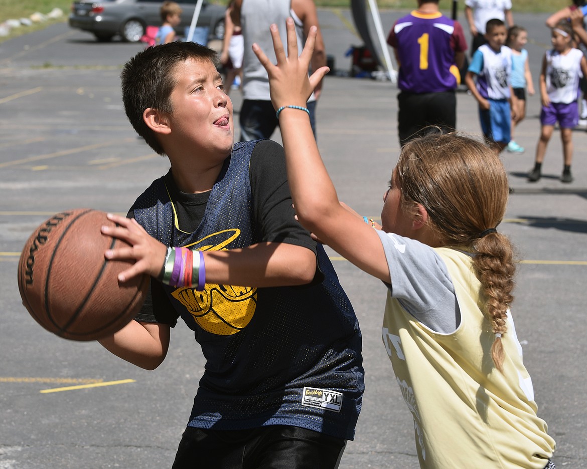 AN ELMO 3-on-3 contestant attempts to shoot over his opponent during the later portion of the 3-on-3 tournament. This is the third-consecutive year the city of Elmo hosted its’ 3-on-3 basketball tournament started by event organizer, and Elmo-resident Howard Walker. (photo by Jason Blasco/Lake County Leader)