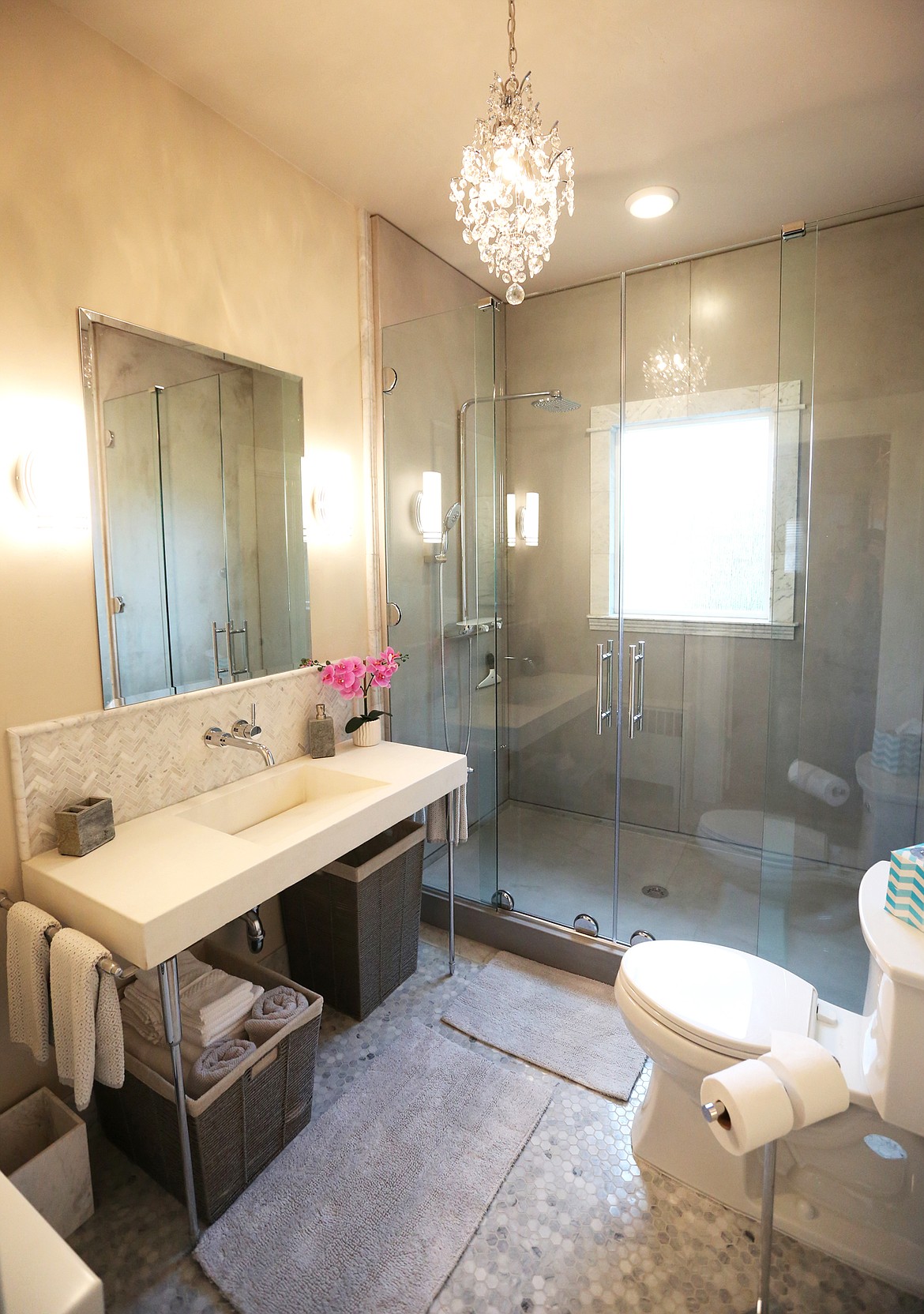 One of the home&#146;s bathrooms features a chandelier, dual sliding glass doors and tile floors. (Mackenzie Reiss/Daily Inter Lake)