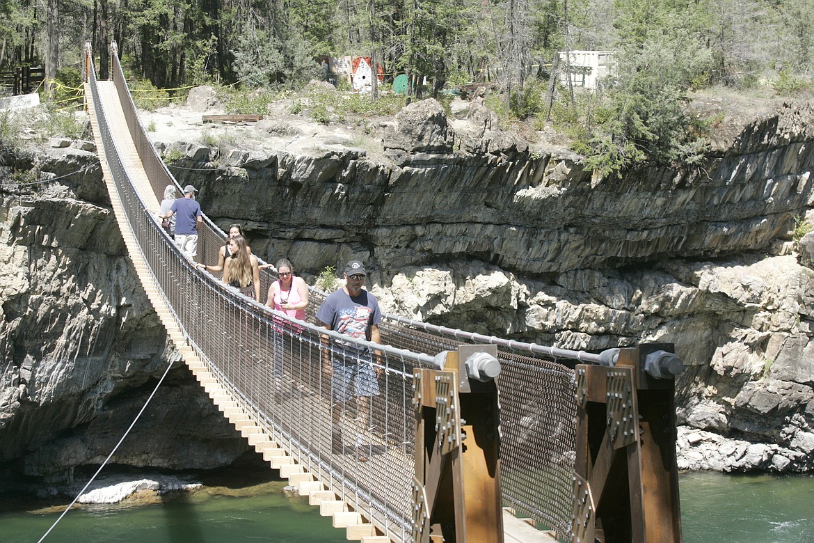 Visitors enjoyed a warm summer day Thursday as they crossed the new swinging bridge across the Kootenai River, south of Libby. (Paul Sievers/The Western News)