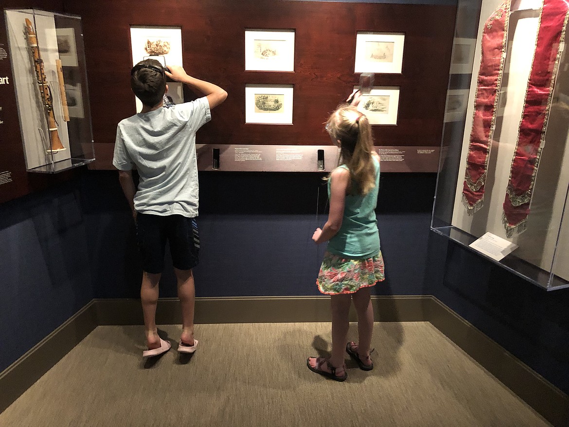 Kloe and her brother, Radley, enjoy the use of magnifying glasses to look at old illustrations concerning the Mission.