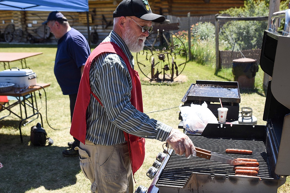 Johnnie Beebe grills up hotdogs Sunday at the annual Libby Pioneer Society Picnic. (Ben Kibbey/The Western News)