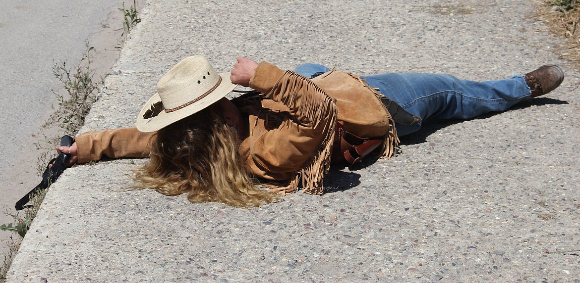 A cowgirl lies on the ground following a dramatic shoot-out at Sportsman Bar. (Maggie Dresser/Mineral Independent)