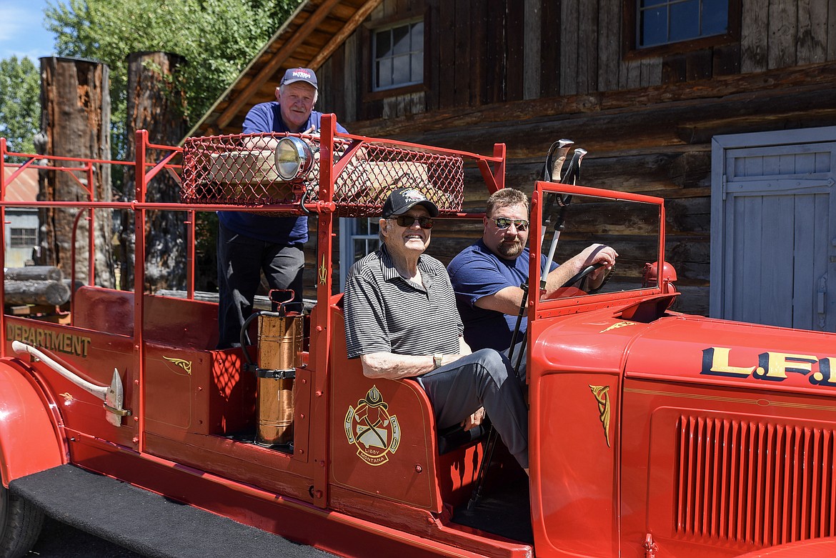 Libby Pioneer Society President Bob Stickney, standing, and Gene Yahvah get ready to take a ride in a vintage fire engine from the Libby Volunteer Fire Department as LVFD firefighter Dan Davis prepares to drive, Sunday at the annual Libby Pioneer Society Picnic. (Ben Kibbey/The Western News)