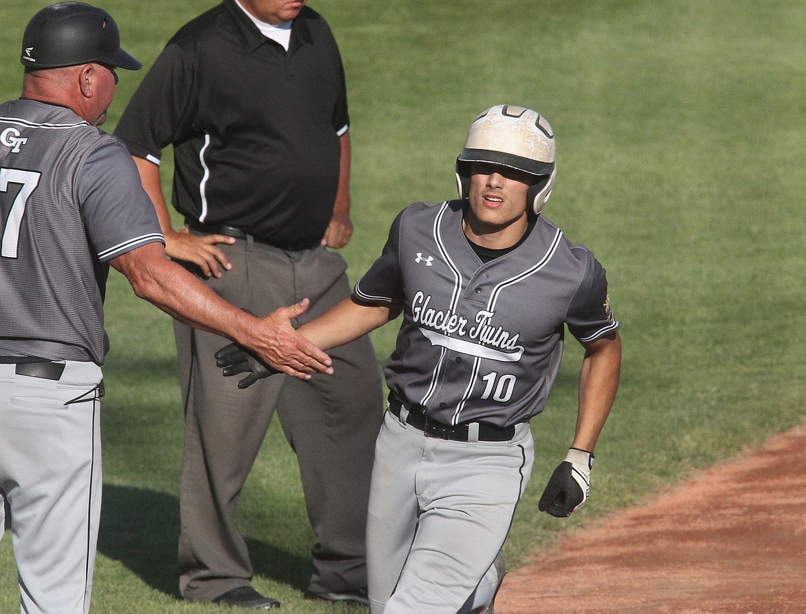 Coby Clark-Dickinson hi-fives his team after a home run in the West A District Tournament last weekend in Libby. (Paul Sievers photo)