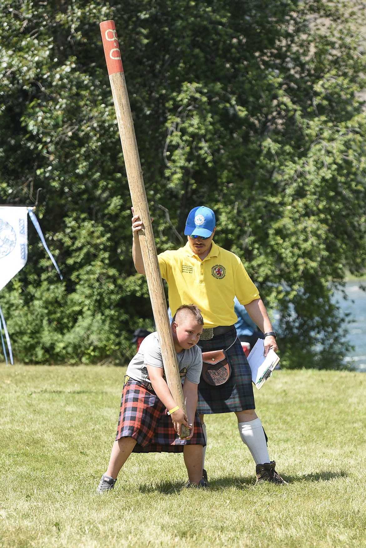 Alex Nelson is assisted by Christian Beach as he prepares to compete in the caber toss, Saturday at the Kootenai Highland Gathering and Celtic Games. (Ben Kibbey/The Western News)