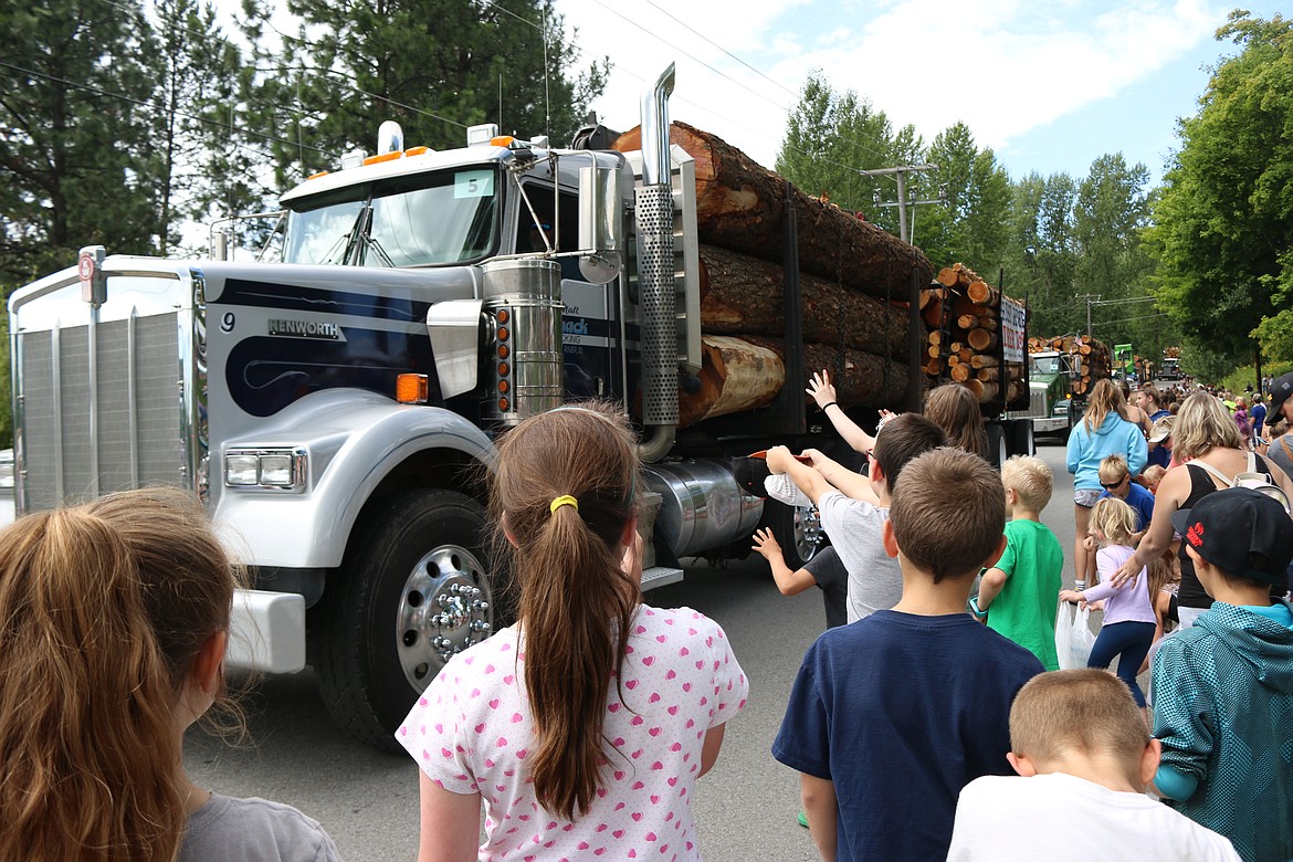 (Photo by MARY MALONE)
Log trucks slowly traverse down High Street during the Timber Days parade on Saturday, with plenty of candy for the kids in the crowd.