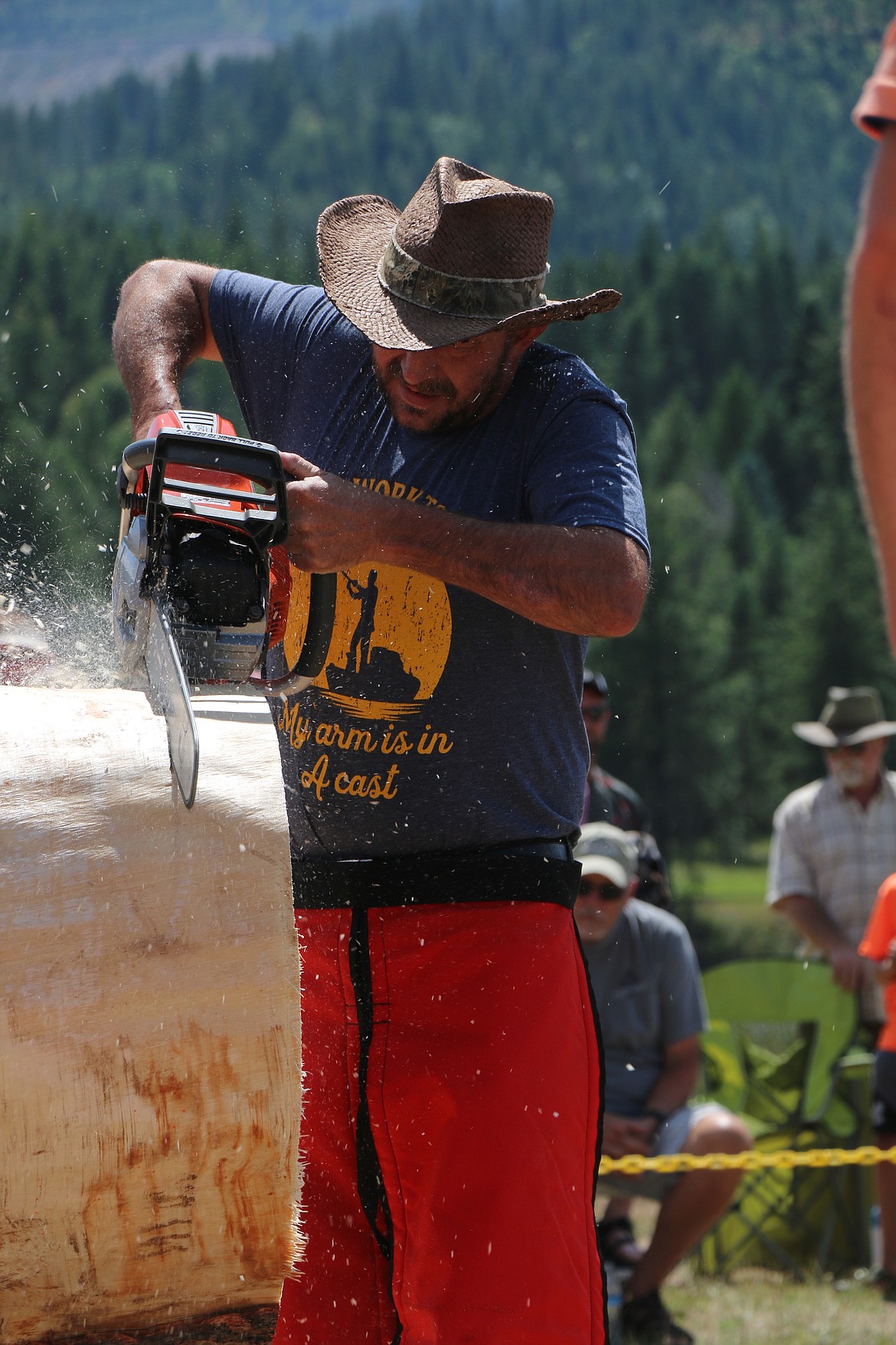 (Photo by CAROLINE LOBSINGER)
A logger begins cutting through a log as he takes part in the annual Priest River Timber Days logging competition.