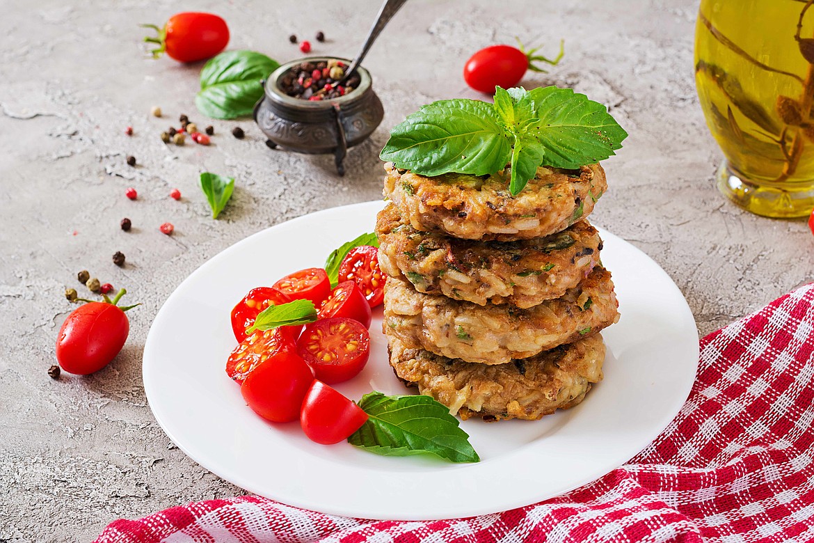 Spicy vegan burgers with rice, chickpeas and herbs. Salad tomato and basil.