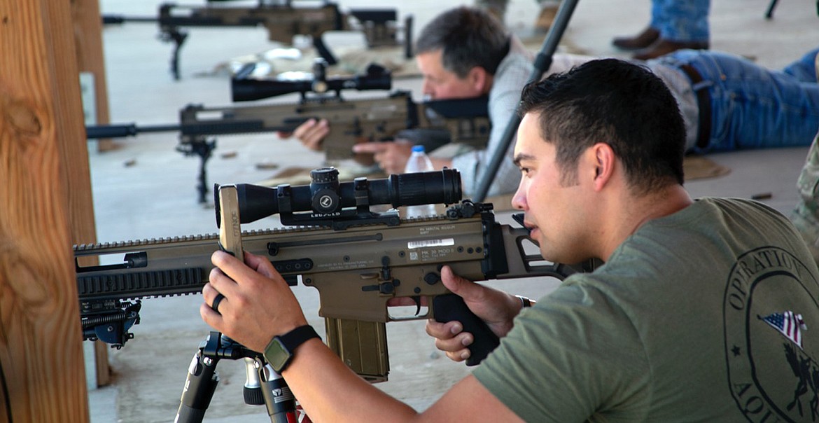LIBBY NATIVE Brian Sharp lines up a shot next to Montana Senator Steve Daines at the U.S. Army base in Colorado Springs. The two shot together in a friendly competition recently after Sharp had returned after being wounded by enemy fire earlier this year in Afghanistan. (Courtesy photo)