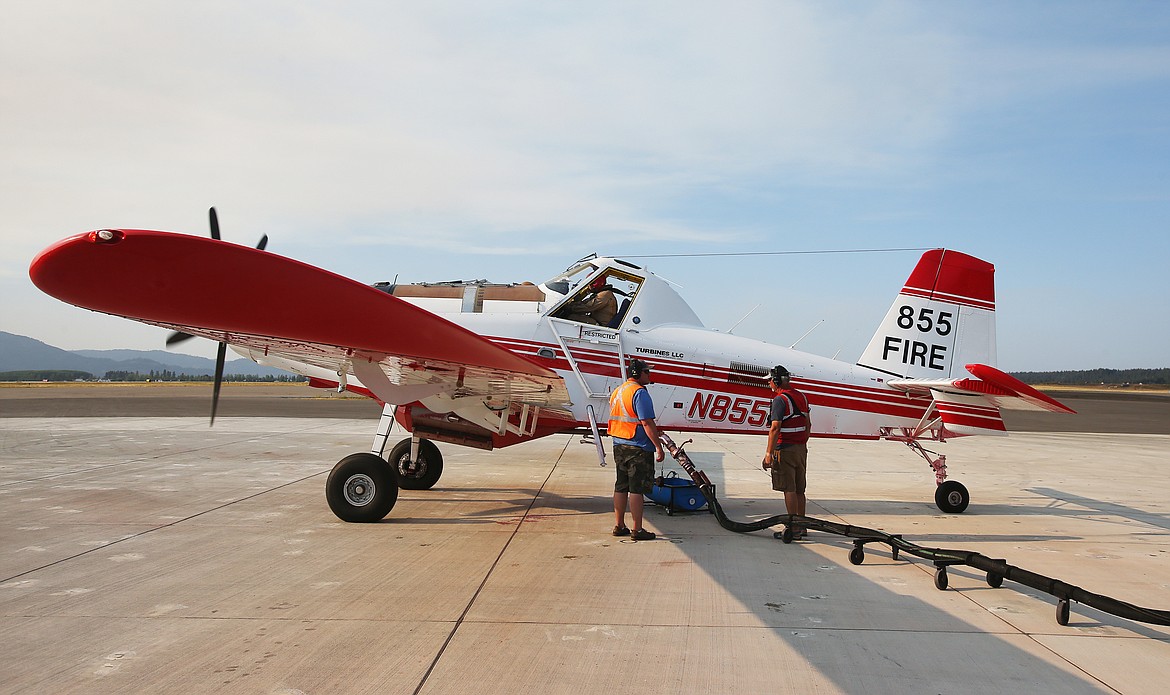 Ramp technicians Tylor Paxton, left, and Gary Holmbo fill a single engine aircraft with fire retardant at the Coeur d&#146;Alene Airport air tanker base before it takes off to fight a fire northwest of Athol on Monday. (LOREN BENOIT/Press)