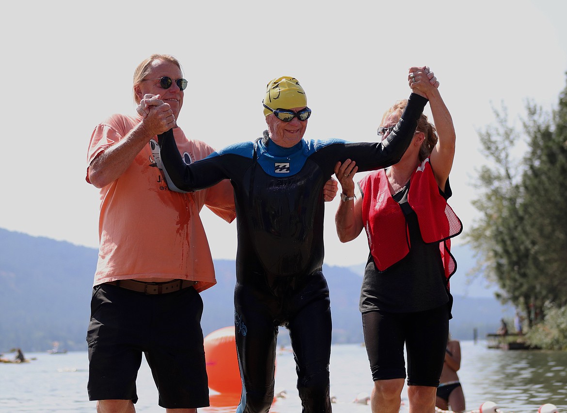 (Photo by KYLE CAJERO)
Charles &#147;Chuck&#148; Milton, flanked on the left by his son Charles Jr., celebrates after becoming the oldest Long Bridge Swim finisher on Aug. 3. Milton, 90, finished the 1.76-mile swim in 1:42:40.