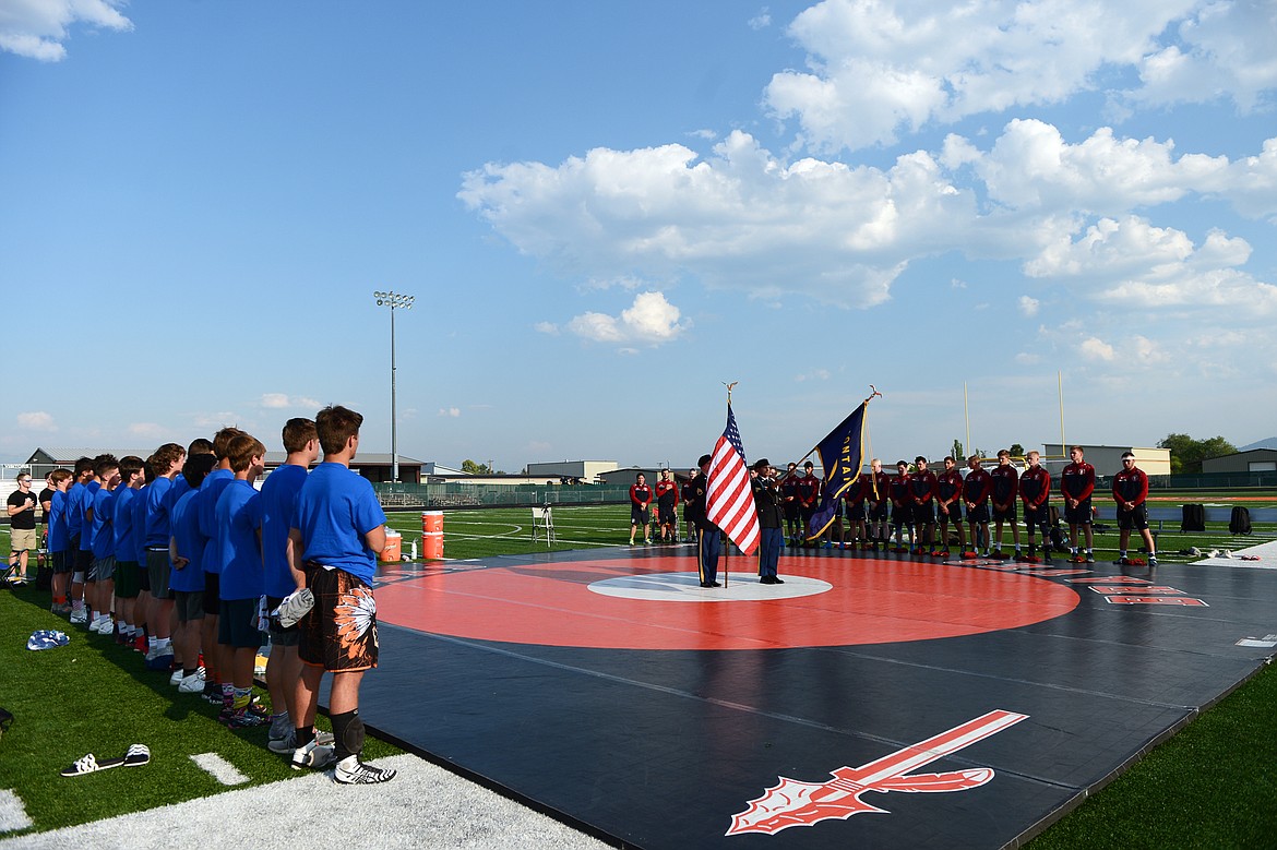 Flathead Valley and Baden-W&uuml;rttemberg wrestlers line up along the mat as the American and German national anthems are sung before an annual cultural exchange wrestling exhibition at Legends Stadium on Wednesday. (Casey Kreider/Daily Inter Lake)