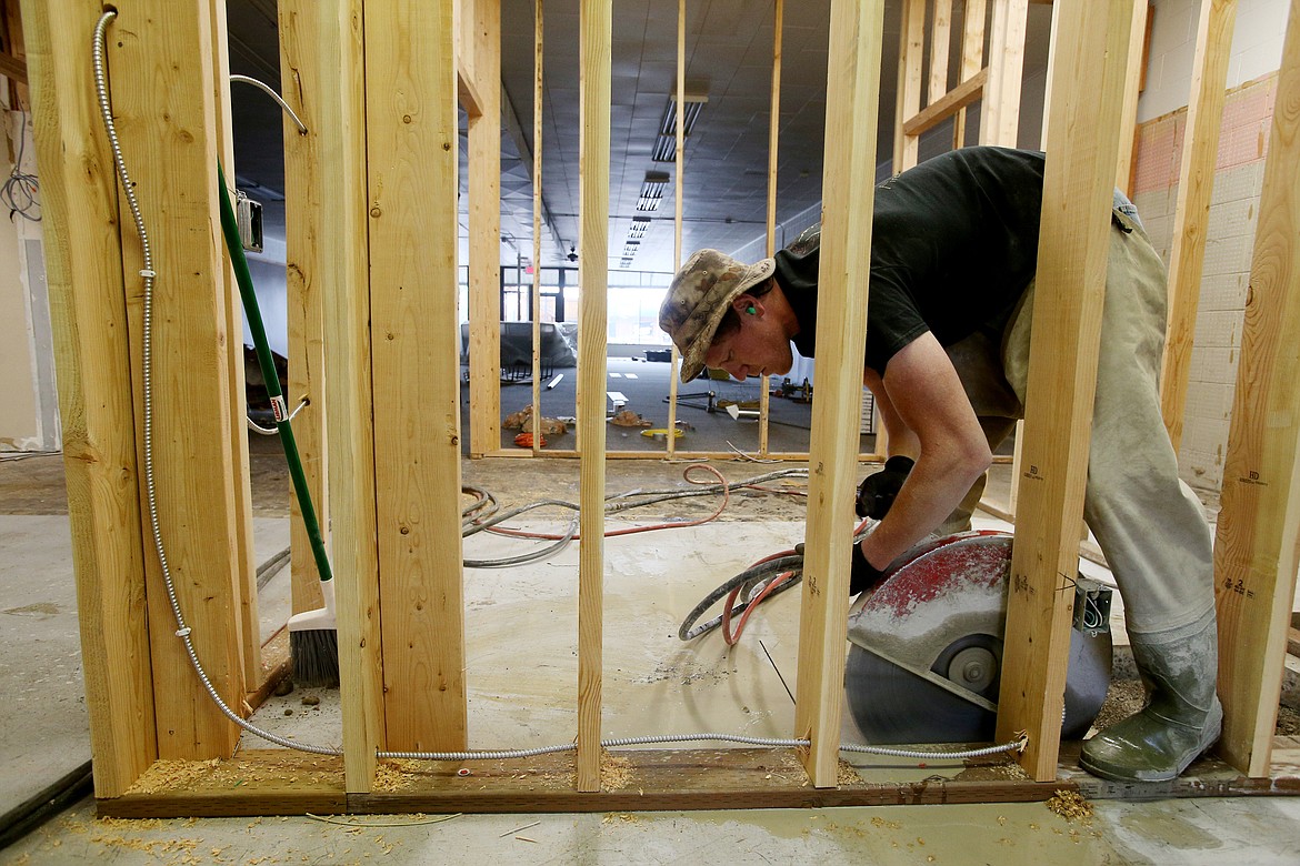 Jake Stuart cuts a piece of cement out for sink pipes in the new mens bathroom at the Hayden Senior Center. (LOREN BENOIT/Press)