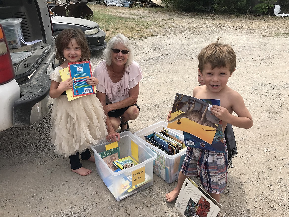 Ruder Elementary School fourth-grade teacher Connie Warner, center, assists some eager children at the Columbia Falls Bookmobile. (Courtesy photo)