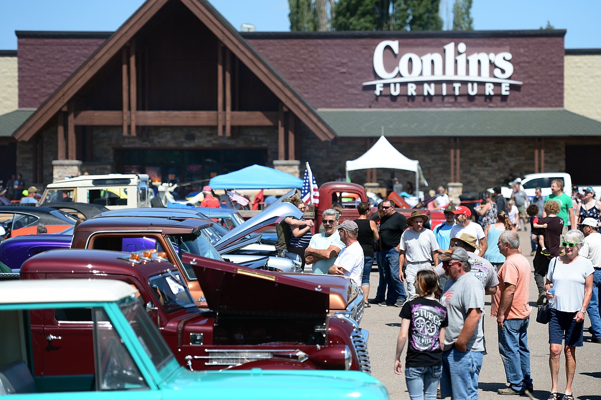 Visitors walk through lanes of cars and trucks on display at the Evergreen Show &#145;n Shine at Conlin&#146;s Furniture in Evergreen on Saturday. (Casey Kreider/Daily Inter Lake)