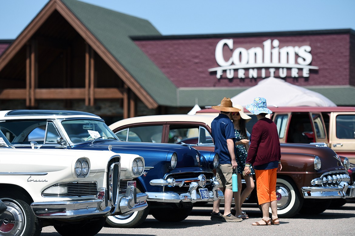 Visitors walk through lanes of cars and trucks on display at the Evergreen Show &#145;n Shine at Conlin&#146;s Furniture in Evergreen on Saturday. (Casey Kreider/Daily Inter Lake)