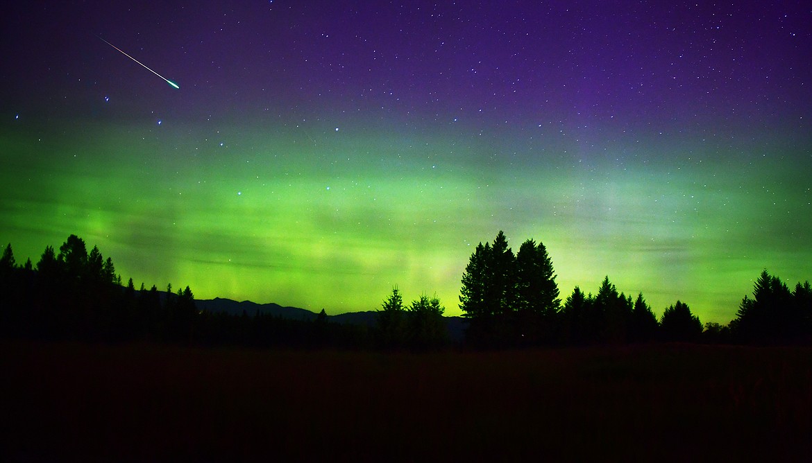 A meteor blazes across the sky while the northern lights glow on the horizon Monday morning. (Jeremy Weber photo)