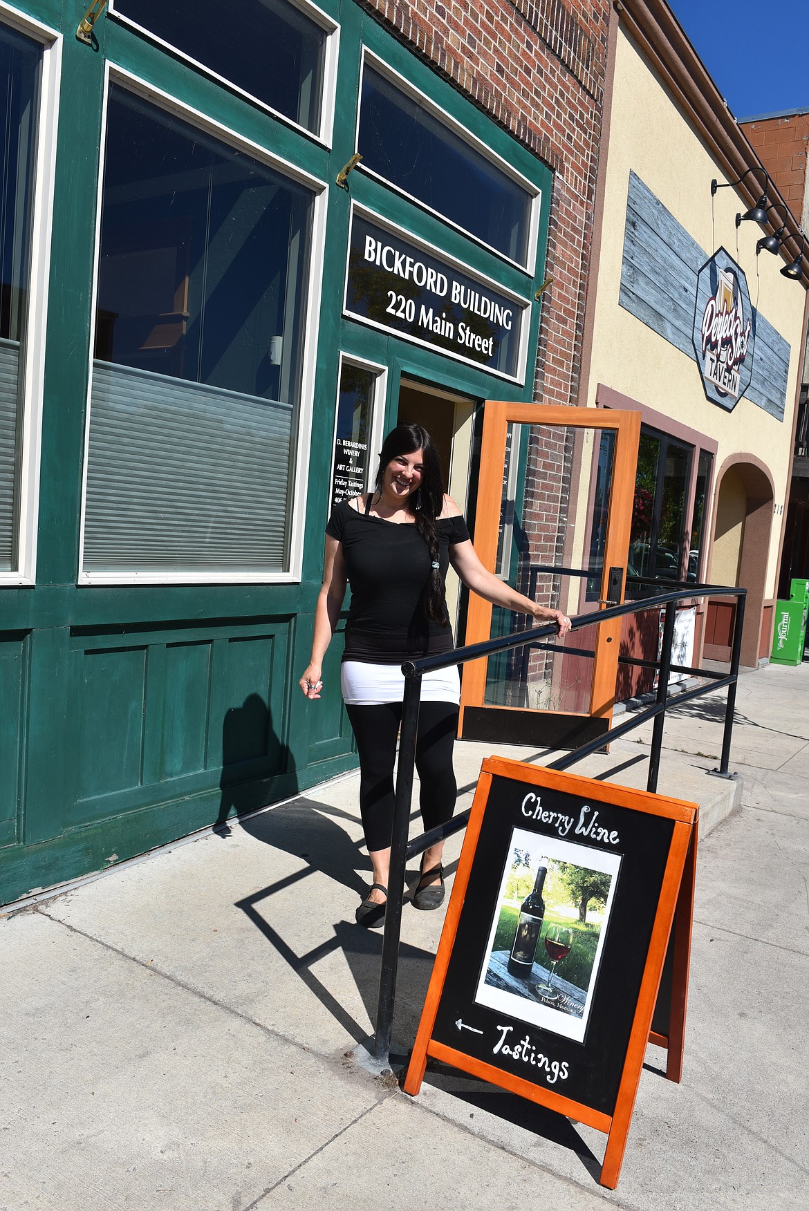 DANA BERDARINIS welcomes Polson Farmers Market shoppers to come into the cool and taste her signature Montana wines. (photo by Carolyn Hidy/Lake County Leader)