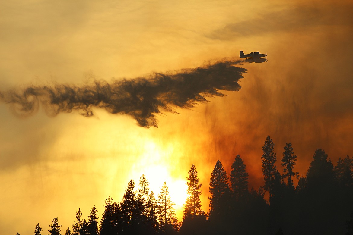A fire suppression aircraft drops water on the CCC wildfire Wednesday afternoon.