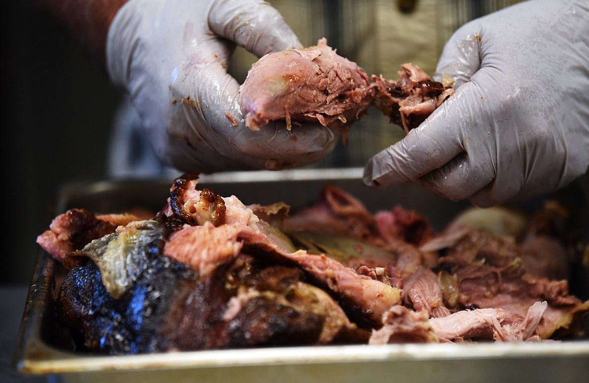 Ed McGrew shreds a smoked pork shoulder which he will wrap individually into one pound packages that sell for $12. Ed McGrew&#146;s BBQ take out counter features pulled pork, ribs, beef brisket, tri-tip and side dishes.
(Brenda Ahearn/Daily Inter Lake)