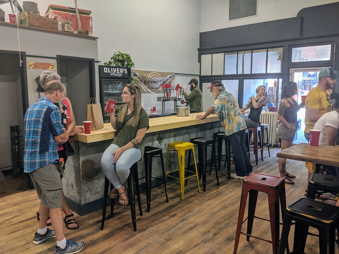 Grand opening attendees test out the bar area inside Oliver&#146;s Mercantile last week. Koski hopes to keep a rotating number of unique beers going through the eight taps on hand.
