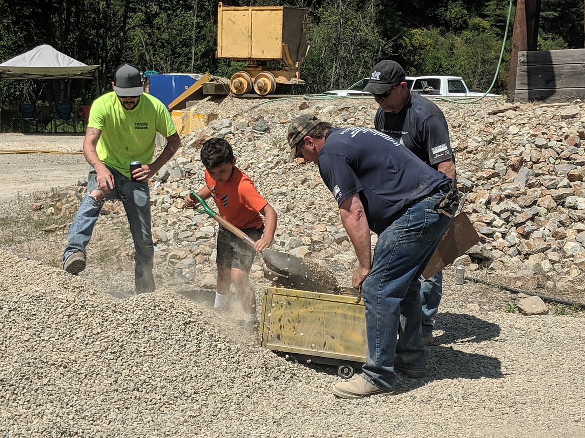 Dustin Coast (left) coaches his son through the kid Hand Mucking event, while judges Dan Michaels and John Weinkauf observe.
