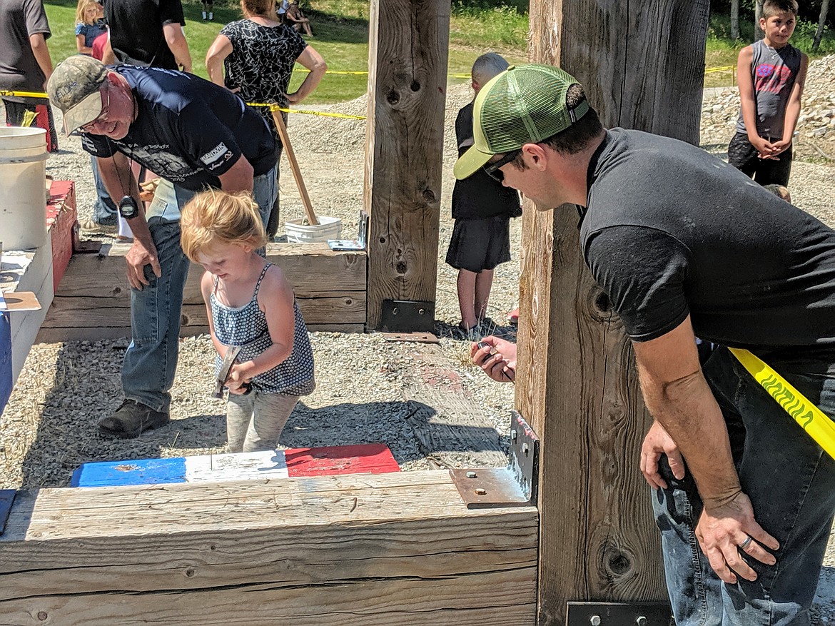 Judge Randy Leetch (left) keeps an eye on the clock, while Corey Reed cheers on his daughter during the kid Spike Driving event.