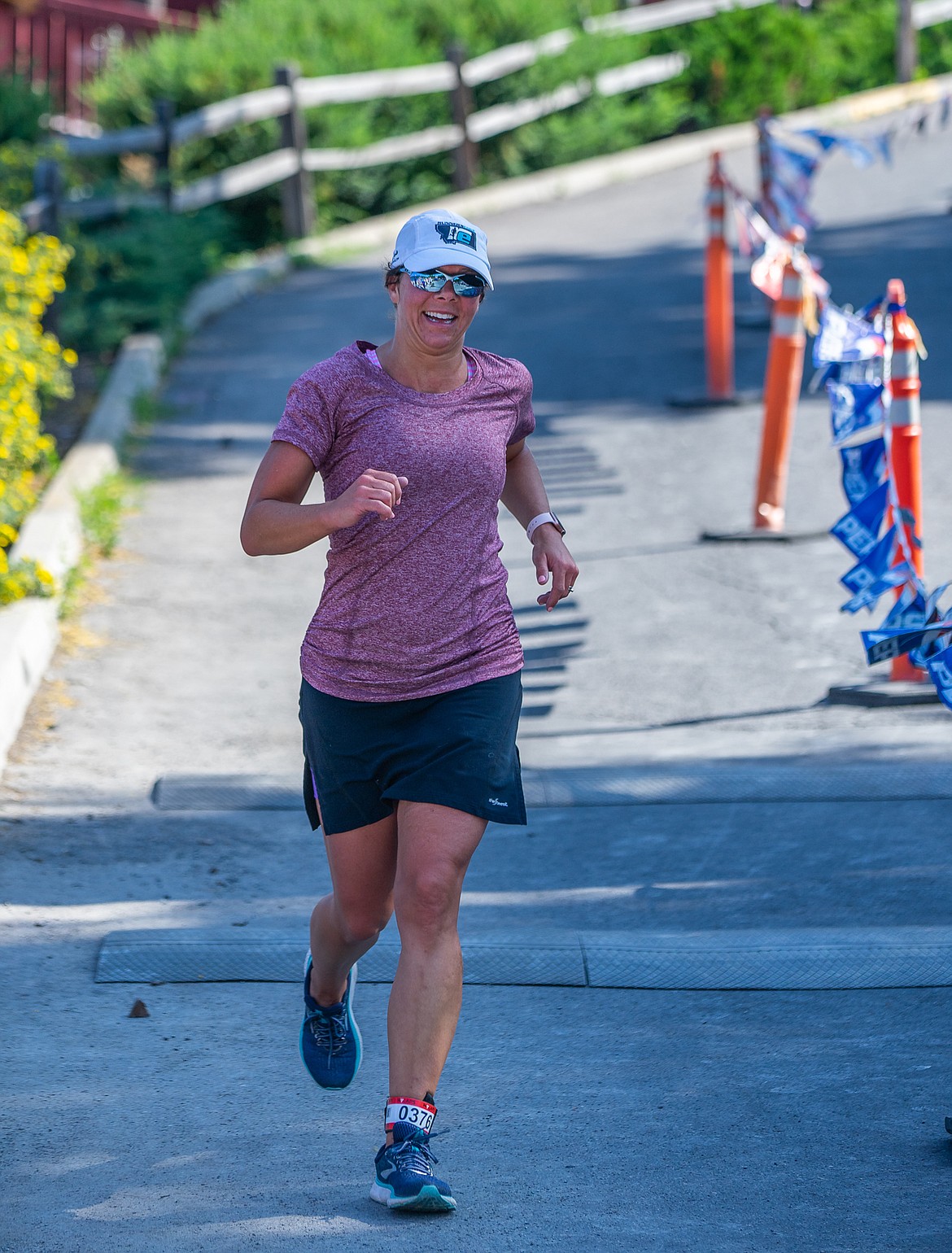 Carrie Jacobs of Whitefish crosses the finish line during the Whitefish Lake Triathlon on Sunday. (Daniel McKay/Whitefish Pilot)