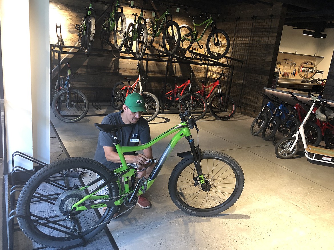 A Silver Mountain bike tech works on a mountain bike during the grand opening celebration.