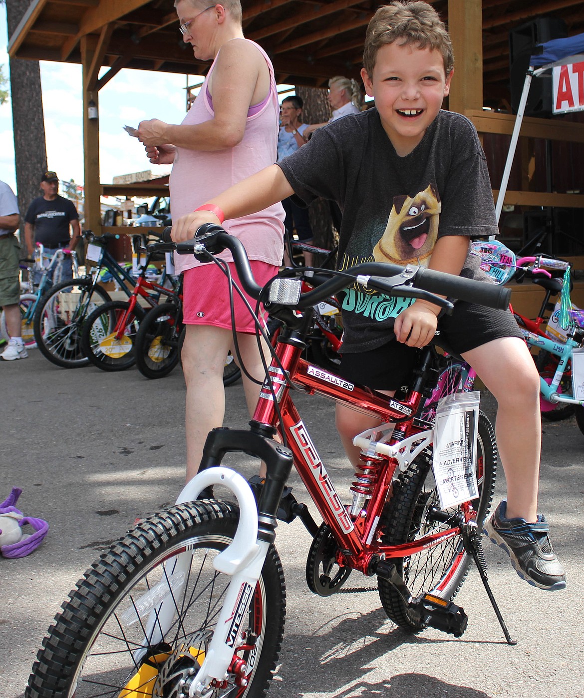 Kameron Meeks, 7, of Superior wins a bike at the bike, fishing pole and tent raffle at the fair on Saturday. (Maggie Dresser/Mineral Independent)