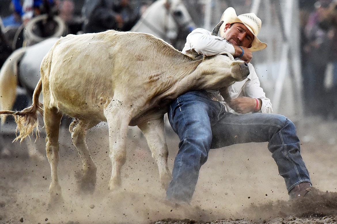 Bridger Chambers, from Stevensville, Montana, brings his steer to the ground during steer wrestling at the Northwest Montana Fair PRCA Rodeo at the Flathead County Fairgrounds on Friday. (Casey Kreider/Daily Inter Lake)